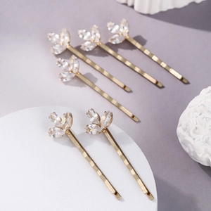 Détail de six barrettes à feuilles dorées ornées de cristaux marquise sur socle en pierre