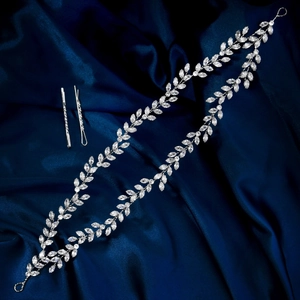 Detailansicht von Silberzirkon-Blatt-Haarband-Set mit passenden Haarklammern auf blauem Seid