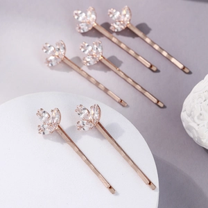 Gros plan de six épingles à cheveux trèfle en or rose avec zircons scintillants