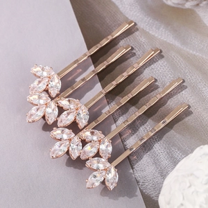 Détail de cinq barrettes en or rose ornées de trèfles en zircons avec une finition polie