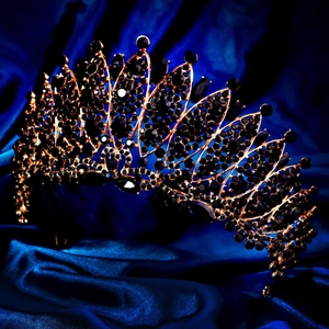 Detailed macro view of black rhinestones and marquise gems on golden Baroque crown