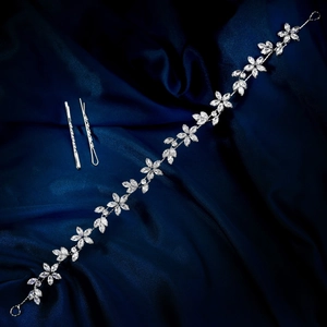 Nahaufnahme des silbernen Brautkopfschmucks mit Zirkon-Blütenblättern auf blauem Satin