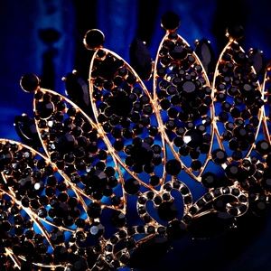 Detailed macro view of black baroque crown with gold filigree and dark gemstones