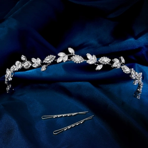 Detailansicht eines Brauthaarbands mit Zirkonia-Blättern auf blauem Satin-Hintergrund