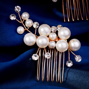 Detailed close-up of bridal hair comb with pearls and rhinestones on blue silk