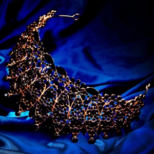 Detailed macro view of black crystal rhinestones set in a vintage golden crown base