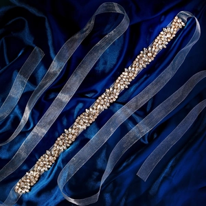 Ceinture de mariée élégante avec strass scintillants sur un fond de satin bleu marine