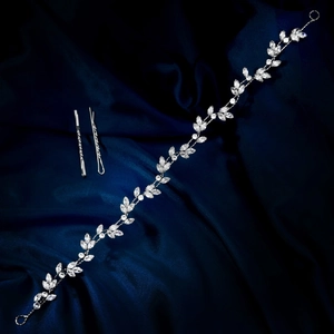 Detailaufnahme von Zirkonia-Braut-Haarband und Blatt-Haarnadeln auf blauer Seide