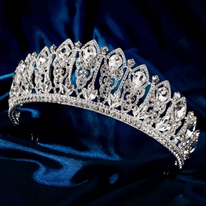 Detailed close-up of a silver bridal tiara with sparkling crystal rhinestones on blue silk