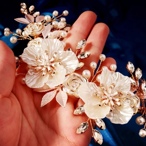 Detailed close-up of handmade bridal hair comb with ivory flowers and gold leaf accents