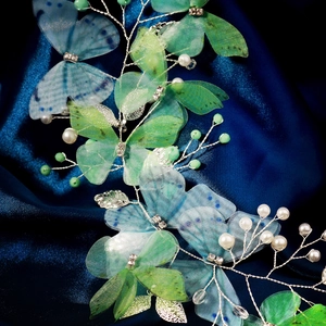 Macro shot of bridal hairband with translucent mesh butterflies, pearls and silver leaves