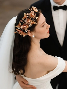 Detailed view of luxury rose gold bridal headband with carved flowers, butterflies and pearls