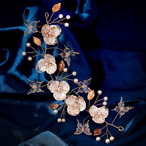 Detail of handmade bridal hair vine with acrylic petals and golden leaves on blue satin