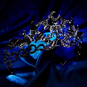 Detailed view of Gothic bat crown with black rhinestones on dark blue silk fabric