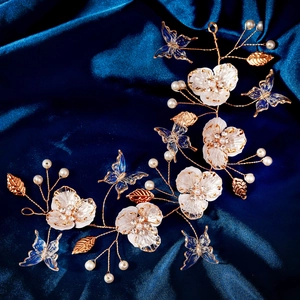 Detail of bridal hair vine with golden wire, blue butterflies, and white flowers