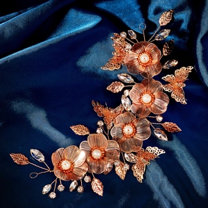 Macro shot of gold metal petal headband with floral pearls and crystal butterfly details