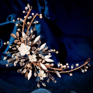 Detail of handcrafted bridal headband with white ceramic flowers and pearls on blue silk