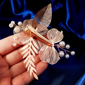 Barrette à cheveux dorée avec perles et motifs de feuilles sur fond de soie bleu profond