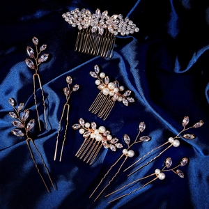 Detailed macro view of crystal flower hair pins and combs set on blue satin