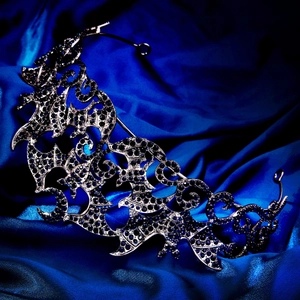 Macro detail of Gothic bat crown with dark blue rhinestones and silver-black metal