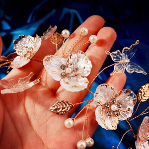 Detail of bridal headband with acrylic petals, rhinestones, and pearls on blue silk