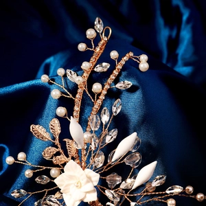 Detail of handmade bridal headband with white resin flowers and crystals on blue silk