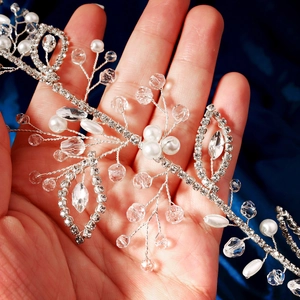 Detail of handmade silver bridal hair vine with pearls, crystals and rhinestones in hand