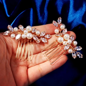 Detail of handmade gold hair pins with zircon flowers and pearls on blue silk background