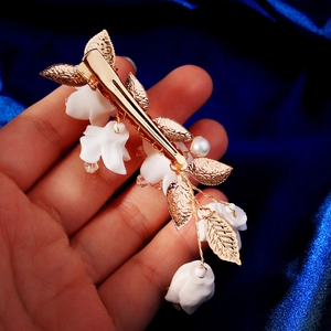 Elegante fermaglio per capelli dorato con fiori in resina bianca e ciondoli in cristallo