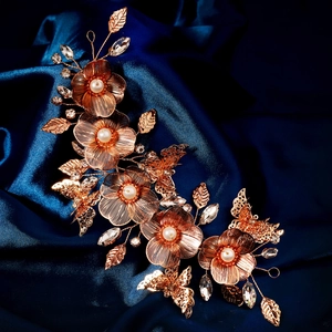 Macro detail of luxury vintage gold floral hairpiece with pearls and shimmering crystals