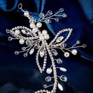 Macro shot of silver bridal hair vine with handmade pearls and sparkling rhinestones