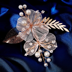 Détail de la pince à cheveux fleurie en fil d'or faite main avec perles sur satin bleu