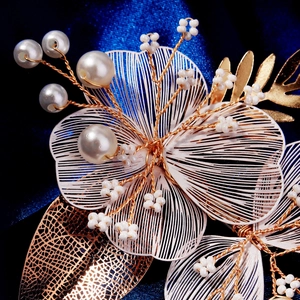 Détail de la pince à cheveux pétale en fil doré faite main avec perles et tissage fin