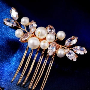 Macro shot of gold floral hair pin with white pearls and marquise crystals