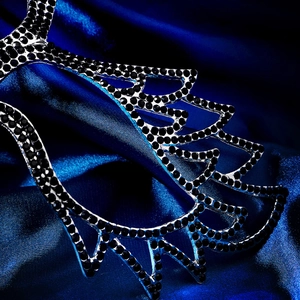 Macro shot of Halloween mask featuring black rhinestones on a silver metal frame