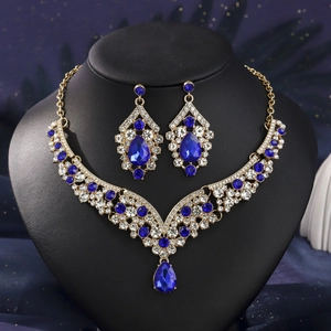 Detailed macro view of luxury V-shape necklace set with blue pear-cut crystals on a bust