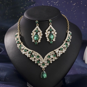Detailed macro view of V-shaped luxury emerald necklace and matching earrings set