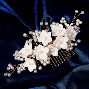 Détail d'un peigne à cheveux de mariée avec fleurs en résine blanche et perles fines