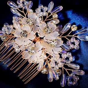 Close-up of handmade bridal hair comb with white matte petals, rhinestones and beads