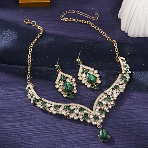 Luxury gold necklace and earrings set with green teardrop gems and white rhinestones
