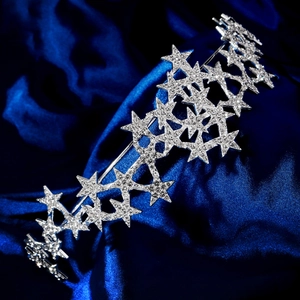 Eleganter silberner Sternenhaarreif mit funkelnden Strasssteinen auf blauem Seidenstoff