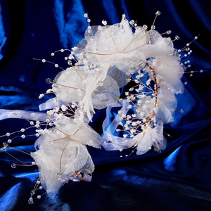 Détail de bandeau fleur en tulle blanc avec perles et cristaux sur soie bleue