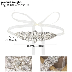 Macro detail of handmade bridal belt featuring crystal rhinestones and white pearls