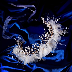 Détail d'un bandeau fleur en tulle fait main avec cristaux et pétales de maille blanche