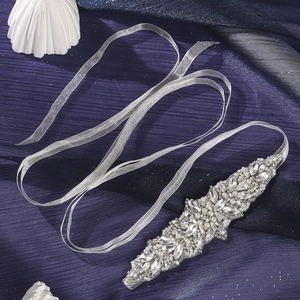 Close-up of handmade bridal belt with marquise rhinestones and pearls on organza