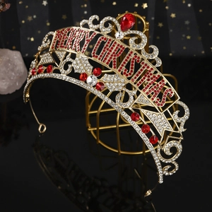 Detail of gold Merry Christmas crown with red rhinestones on a decorative metal stand