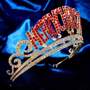 Détail de couronne de Noël dorée avec lettres en strass rouges sur de la soie bleue