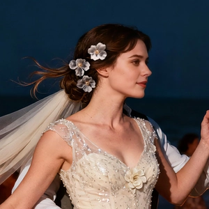 Detailed view of champagne floral bridal hair pins with pearls on a model at night beach