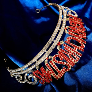 Gros plan sur une couronne de Noël dorée avec strass rouges épelant le mot CHRISTMAS