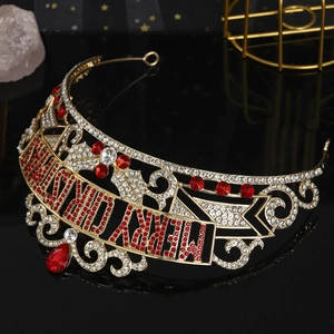 Detail of a gold Christmas crown featuring red rhinestones and Merry Christmas lettering
